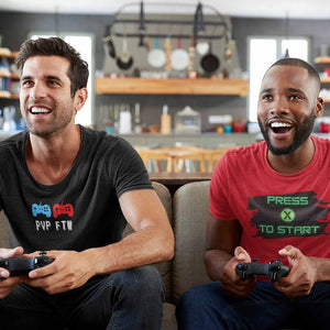 Two guys playing console video game. One with PVP FTW for player vs player for the win and Press X to Start.  Both t-shirts tees